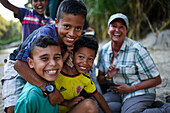 Group of playful local kids having fun with a foreigner woman, Santa Marta, Colombia