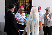 People in typical costumes at La Paloma feasts in Madrid.