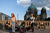 The Benka Boradovsky Bordello Band captivates passersby with lively music on Friedrich Bridge, set against the stunning Berliner Dom.