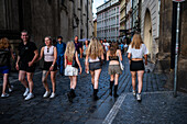 Young girls walking in Prague, view from behind