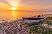 View of boat on pebble beach near Skala Kallirachis at sunset, Skala Kallirachis, Thassos, Aegean Sea, Greek Islands, Greece, Europe