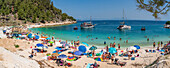 Blick auf eine Strandszene und ein Boot auf dem Meer bei Porto Vathy, Makriammos, Thassos, Ägäisches Meer, Griechische Inseln, Griechenland, Europa