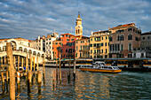 Blick auf bunte Häuser, Rialtobrücke und Canal Grande mit Booten bei Sonnenuntergang, Venedig, UNESCO-Weltkulturerbe, Venetien, Italien, Europa