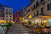 View of restaurants in Mitropolis Square, old Corfu Town at dusk, UNESCO World Heritage Site, Corfu, Ionian Sea, Greek Islands, Greece, Europe