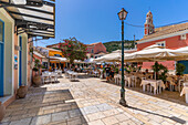 View of cafes and Ascension of the Lord Holy Orthodox Church in Gaios Town, Paxos, Ionian Sea, Greek Islands, Greece, Europe