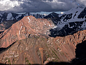 Stunning mountainous landscape of Kyrgyzstan illuminated by fading sunlight and shadowy clouds, Kyrgyzstan, Central Asia, Asia