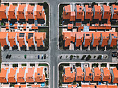 Overhead aerial drone shot showcasing a well-planned suburban area featuring red-tiled homes and organised streets, Portugal, Europe