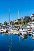 Blick auf Boote und Architektur am Wasser, Aker Brygge, Oslo, Norwegen, Skandinavien, Europa