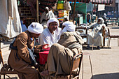 Men sitting in a Daraw street on a market day, Egypt, North Africa, Africa