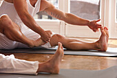 Two people practicing yoga - headless close up