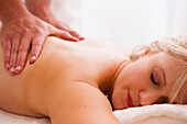 Close up of a masseur hands giving a woman a massage