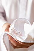 Close up of a waiter's hands polishing a wine glass with a napkin