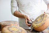 Man rubbing off cheese mold