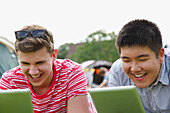 Laughing Teenage Boys Using Tablets