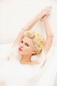 Young Woman in Hair Rollers Having a Bath