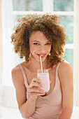 Young Woman Drinking Smoothie with Straw