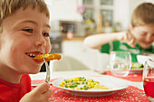 Young Boy Eating Fish fingers and Vegetables