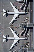 View from above airplanes at passenger boarding bridge on airport tarmac