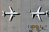 View from above airplanes parked face to face on sunny airport tarmac