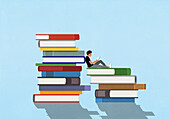 Young man reading among large stacks of books