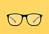 Large eyeglasses on yellow background