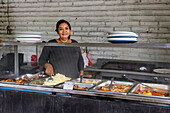 Frau serviert traditionelles Essen in El Salvador