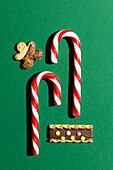 Top view of Christmas sweets and biscuits on a green background