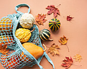 Autumnal composition with various pumpkins in an eco-lace bag