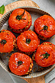 Roasted stuffed tomatoes with brown rice and herbs in ceramic dish