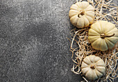 Autumn leaves and pumpkins against a grey concrete background