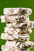 Stacked slices of white nougat Turron de Alicante on a green background