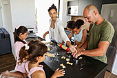 Family baking biscuits together in a modern kitchen