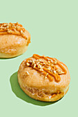 Vegan donuts filled with carrot cake with icing and nut topping
