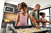 Family baking biscuits together in a modern kitchen