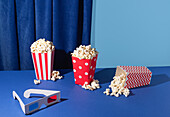 Various popcorn buckets and 3D glasses on a blue background