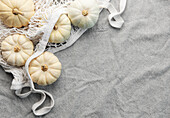 Autumn composition from above with pumpkins in a mesh shopping bag