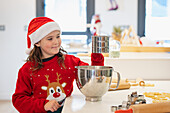 Junges Mädchen in Weihnachtskleidung beim Backen in der Küche