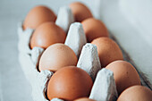 Close-up of fresh brown eggs in a carton