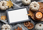 Autumnal composition. Photo frame, pumpkins, dried leaves