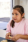 Young girl baking biscuits in a kitchen