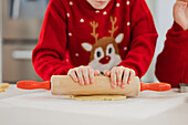Zwillinge backen zu Weihnachten in festlichen Pullovern