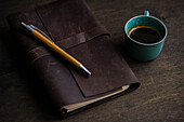 View from above of coffee cup and notebook on wooden table