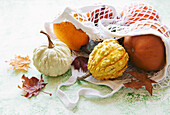 Autumnal composition with various pumpkins in an eco string bag