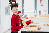 Twins preparing Christmas biscuits in a festive kitchen