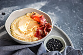 Hummus bowl with Jamon from top view, Mediterranean cuisine