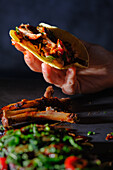 Close-up of rib tacos in a woman's hand