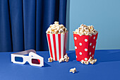 Popcorn bucket and 3D glasses against a blue background