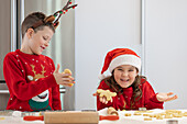 Twins enjoy Christmas cooking together in festive clothes