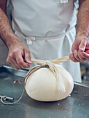 Artisan tying Mahon Menorca cheese in a workshop