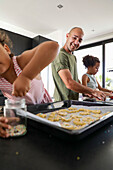 Family enjoys baking biscuits together in the kitchen